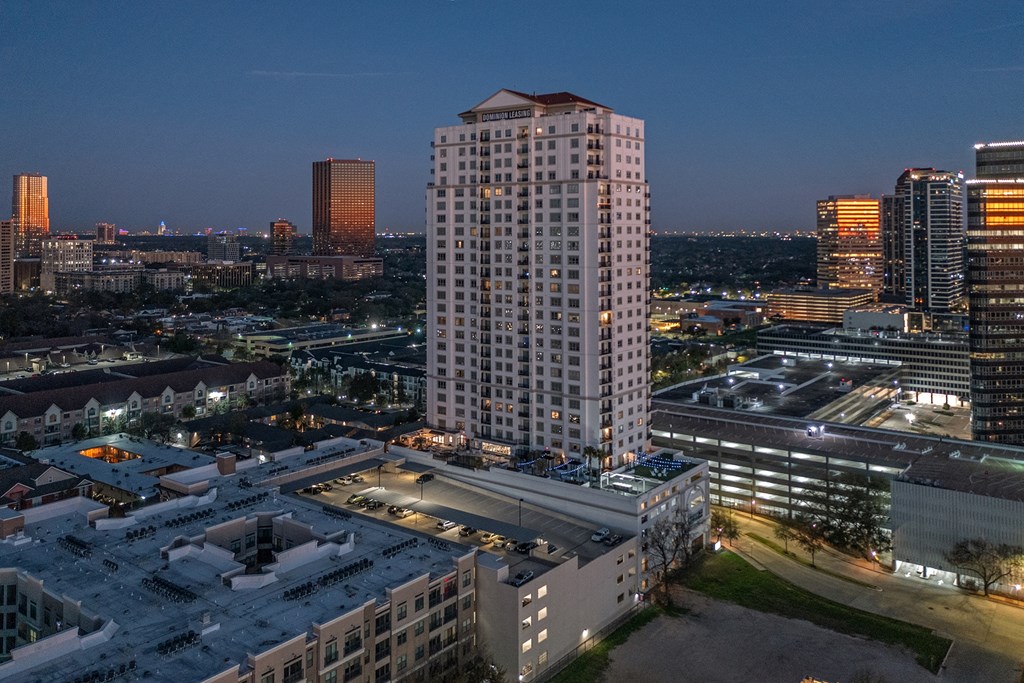 an aerial view of apartment building in the middle of a city at night at Dominion Post Oak in Houston, TX
