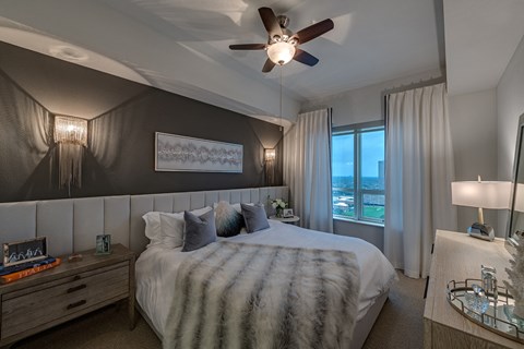 a bedroom with a bed and a ceiling fan  in Houston, TX