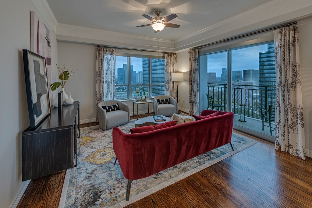a living room with a red couch and a large window  in Houston, TX