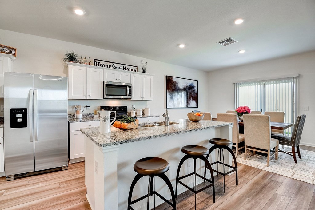 the kitchen and dining area of a modern home with stainless steel appliances