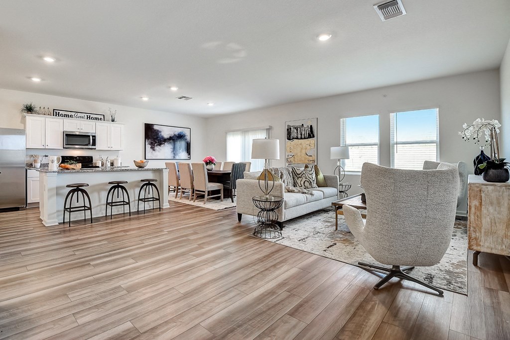 a spacious living room with a kitchen and a dining room