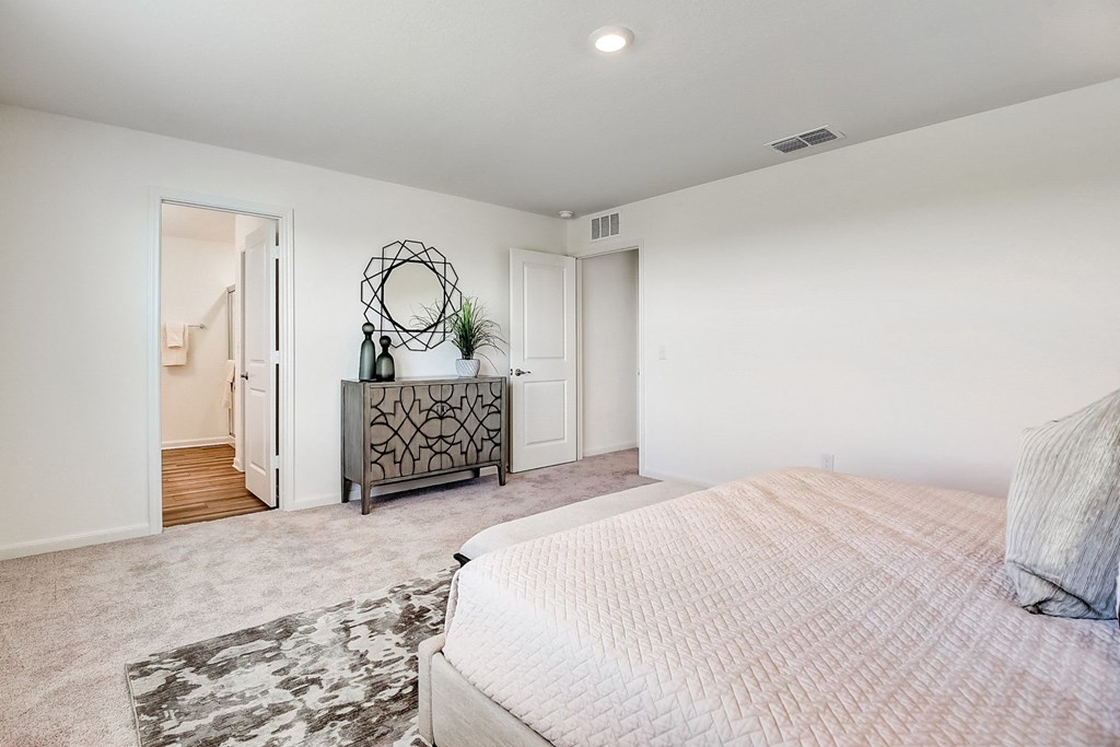 master bedroom with carpet floor, a mirror and a dresser