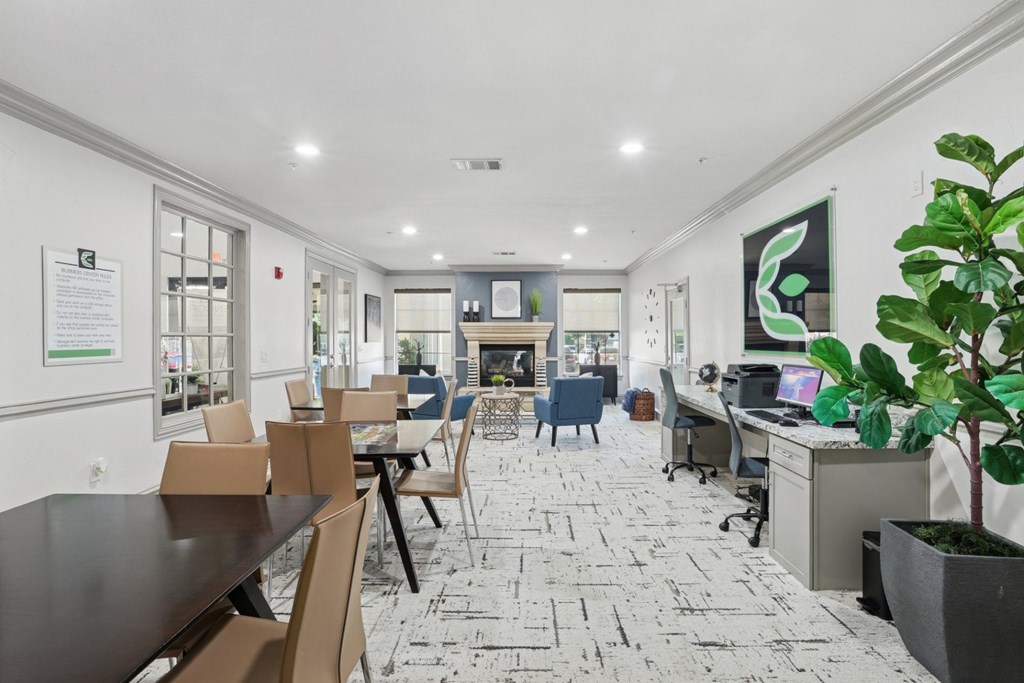 A business center with computers, tables and chairs, and a printer at Encore at Buckingham Apartments in Richardson, TX
