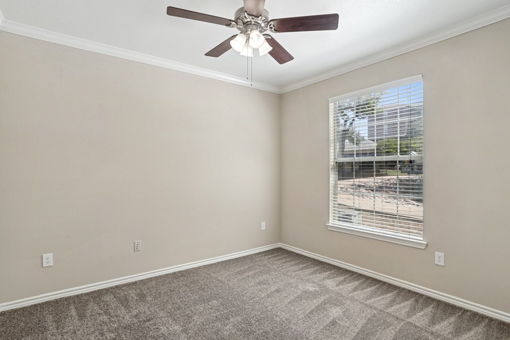 Edinburgh bedroom with a ceiling fan and a window at Encore at Buckingham Apartments in Richardson, TX
