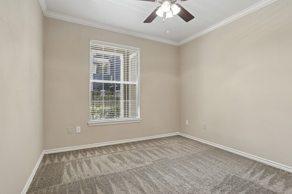 Edinburgh bedroom with a ceiling fan and a window at Encore at Buckingham Apartments in Richardson, TX