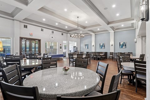 A large event room with round tables and chairs at Encore at Buckingham Apartments in Richardson, TX