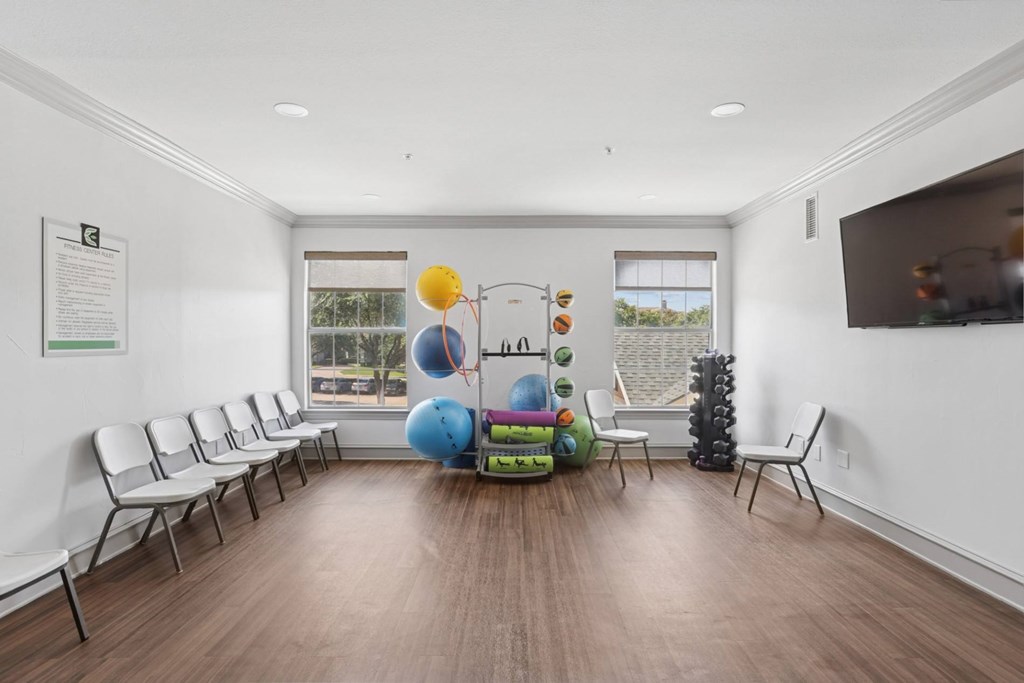 A fitness center with weights, yoga equipment, and a TV at Encore at Buckingham Apartments in Richardson, TX