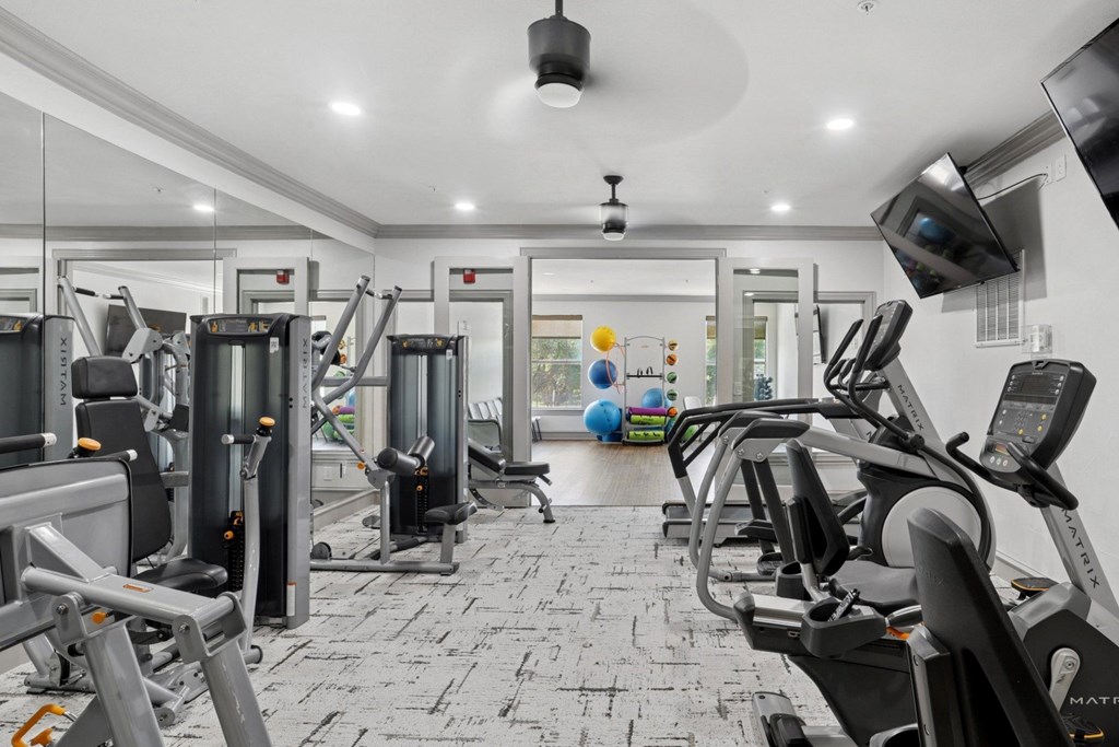 A fitness center with yoga balls and strength training equipment at Encore at Buckingham Apartments in Richardson, TX