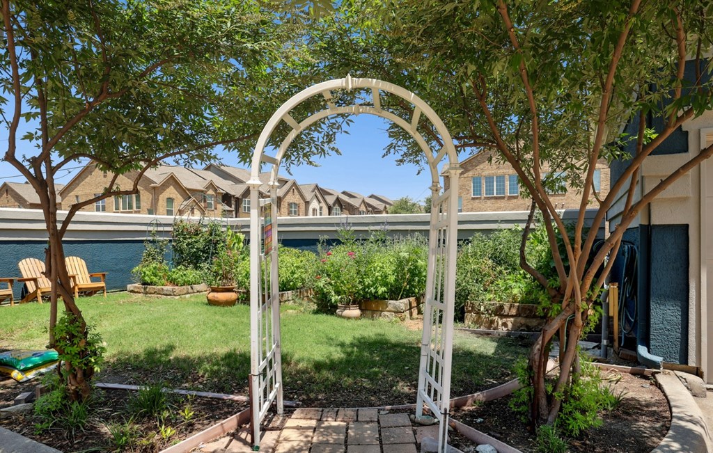 An arch entrance to a garden at Encore at Buckingham Apartments in Richardson, TX