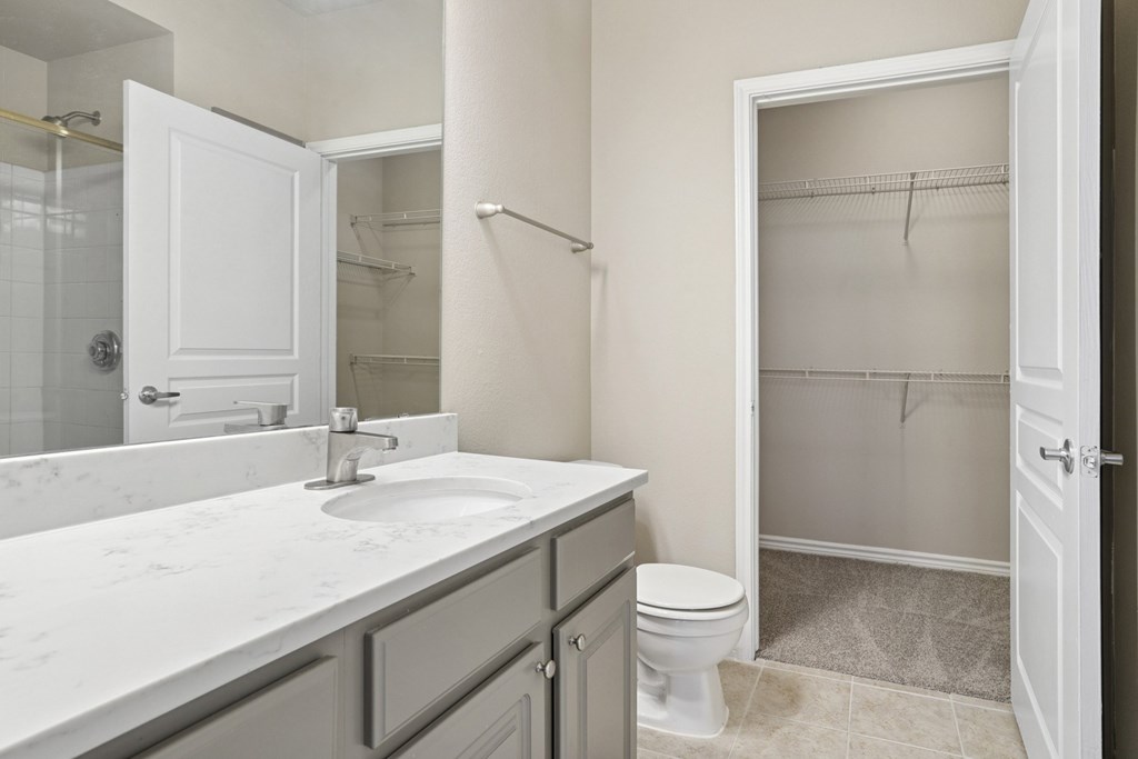 Kenzington bathroom with a white sink and toilet at Encore at Buckingham Apartments in Richardson, TX