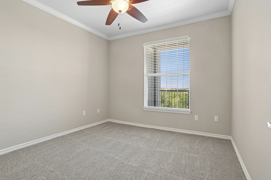 Kenzington bedroom with a carpet and ceiling fan at Encore at Buckingham Apartments in Richardson, TX