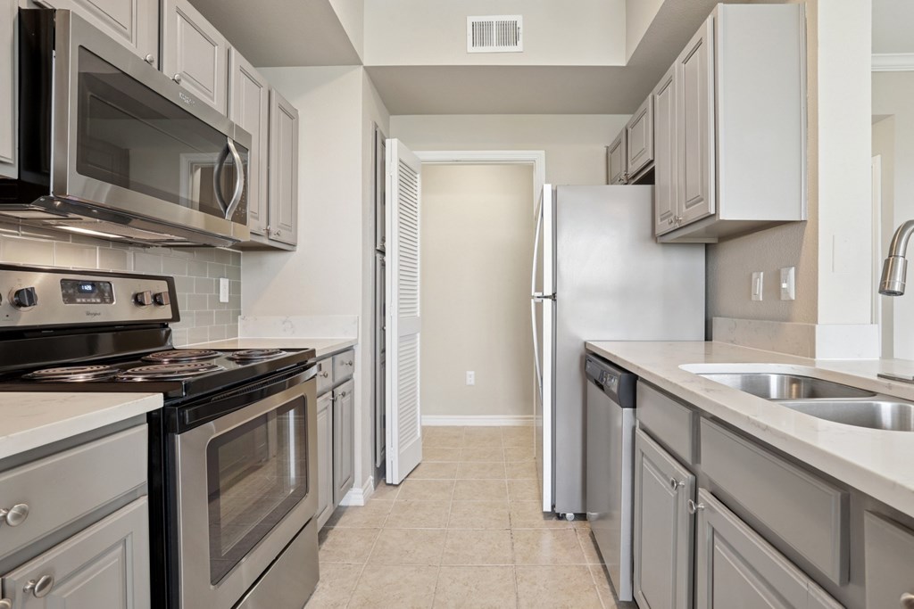 Kenzington kitchen with stainless steel appliances at Encore at Buckingham Apartments in Richardson, TX