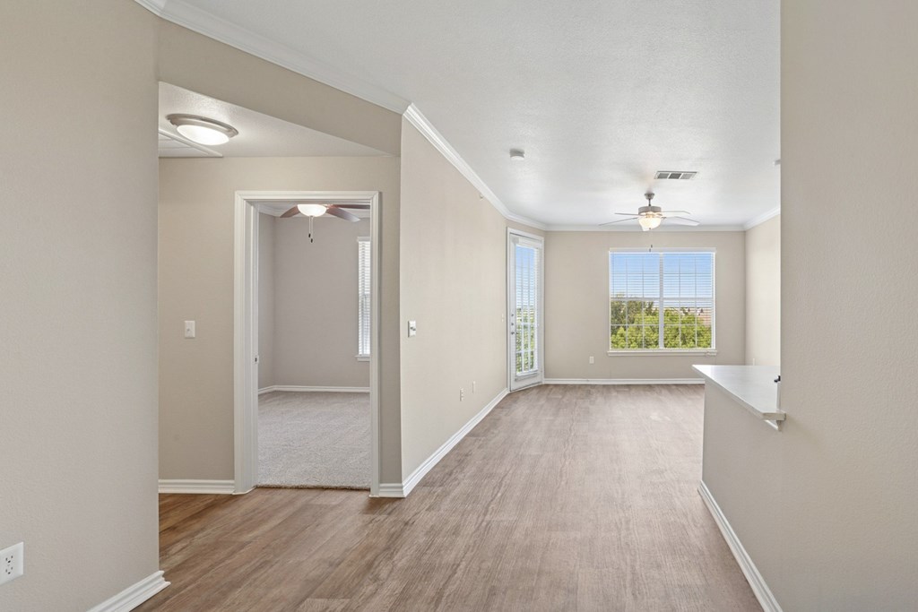 Kenzington living room with a carpeted floor and a ceiling fan at Encore at Buckingham Apartments in Richardson, TX