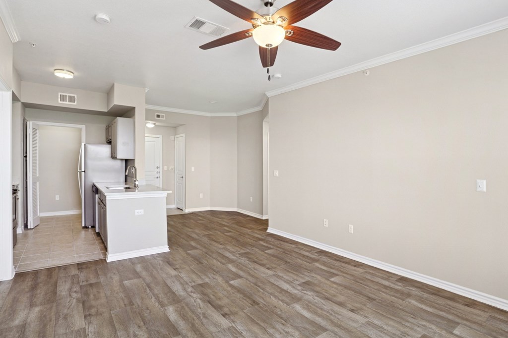 Kenzington living room with wood floors and a ceiling fan at Encore at Buckingham Apartments in Richardson, TX