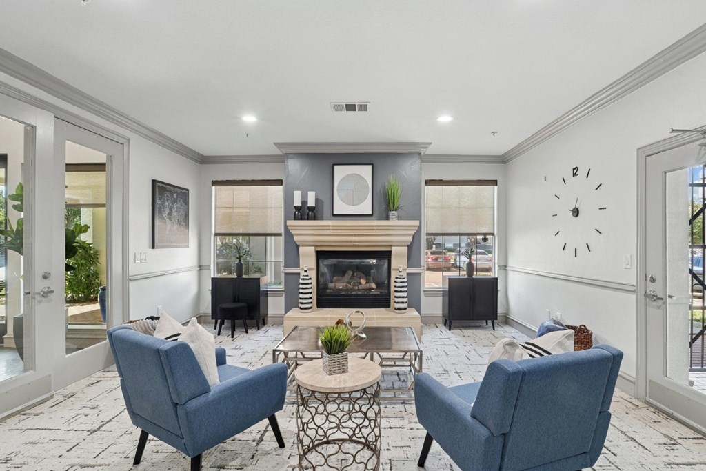 A leasing office with a fireplace and chairs at Encore at Buckingham Apartments in Richardson, TX