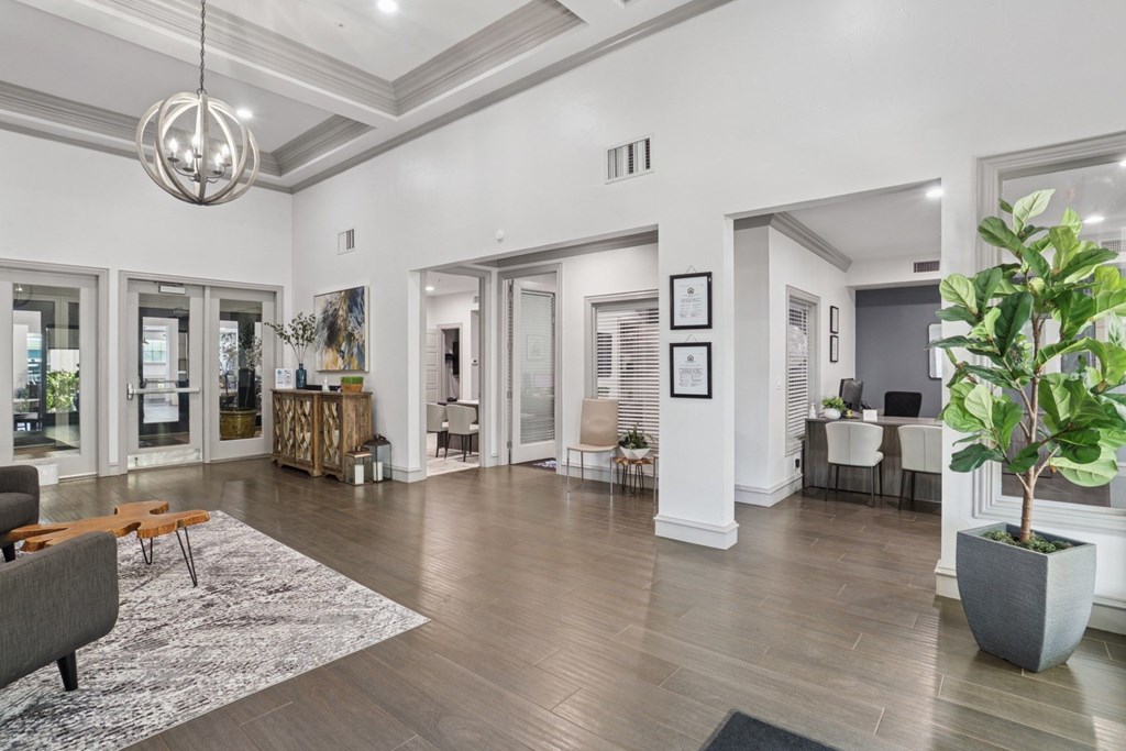 A leasing office with a grey sofa and a large rug at Encore at Buckingham Apartments in Richardson, TX
