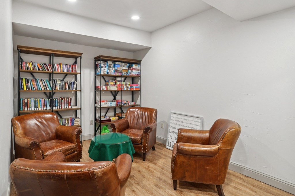 A library with bookshelves and comfortable chairs at Encore at Buckingham Apartments in Richardson, TX
