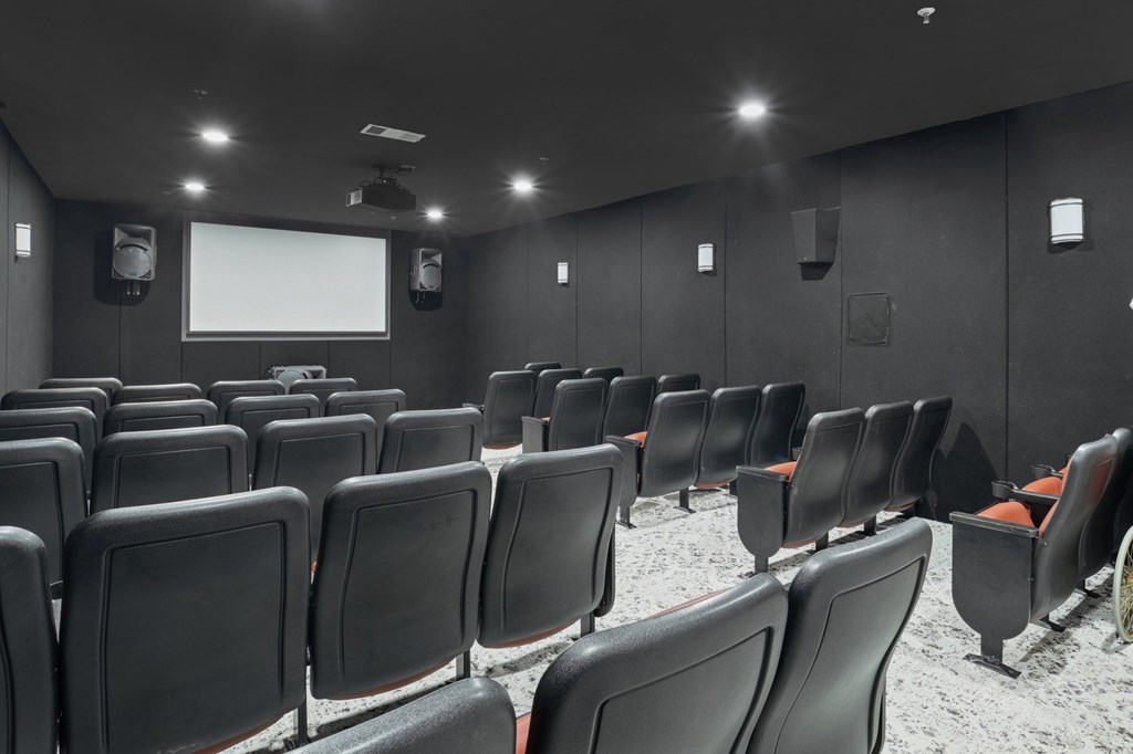 A movie theater with dark walls and speakers at Encore at Buckingham Apartments in Richardson, TX