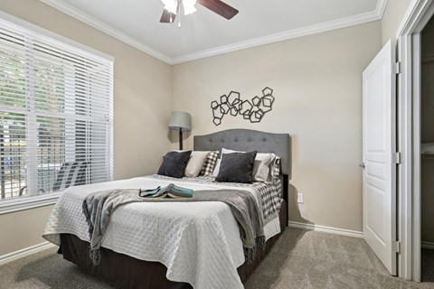 Windsor bedroom with carpet, a window, and a ceiling fan at Encore at Buckingham Apartments in Richardson, TX