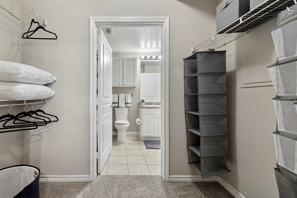 Windsor white bathroom with a walk in closet at Encore at Buckingham Apartments in Richardson, TX