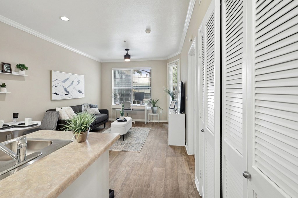 Windsor living room with a dining area and a sofa and window at Encore at Buckingham Apartments in Richardson, TX