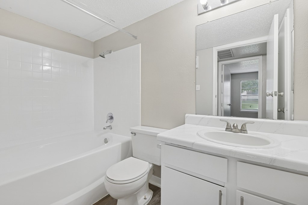 A3 white bathroom with a toilet, vanity sink, and bathtub at Estelle Creek North Apartments in Irving, TX