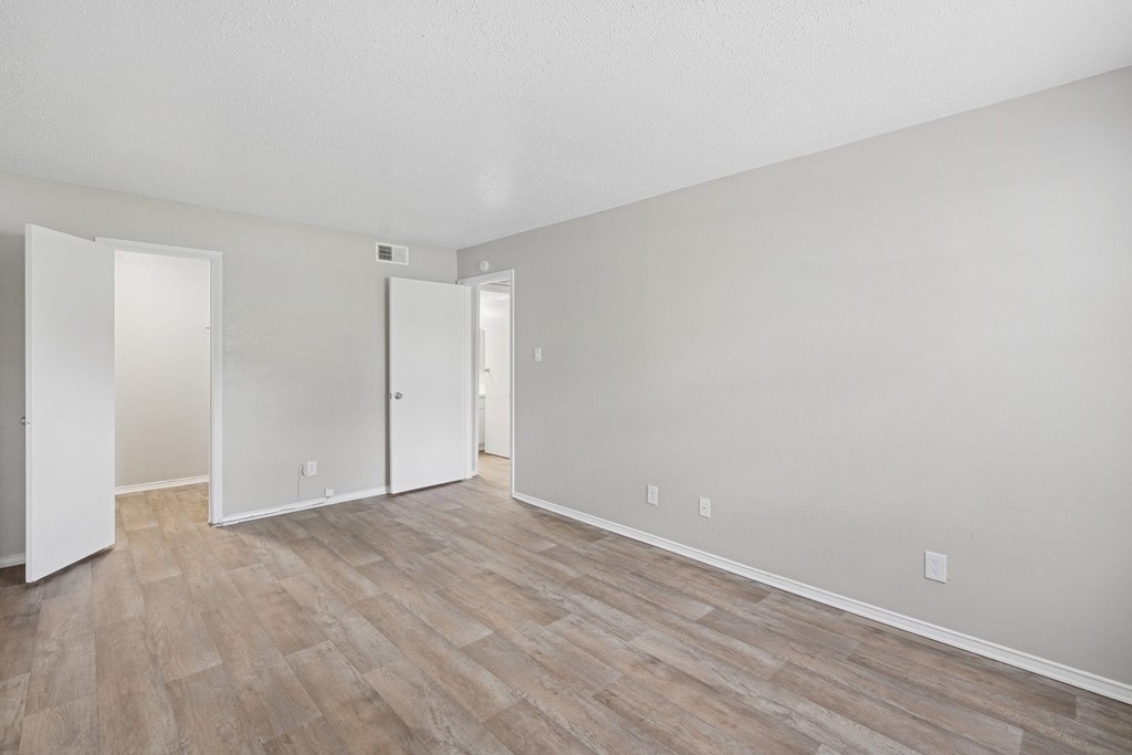 A3 bedroom with wood flooring and white walls at Estelle Creek North Apartments in Irving, TX