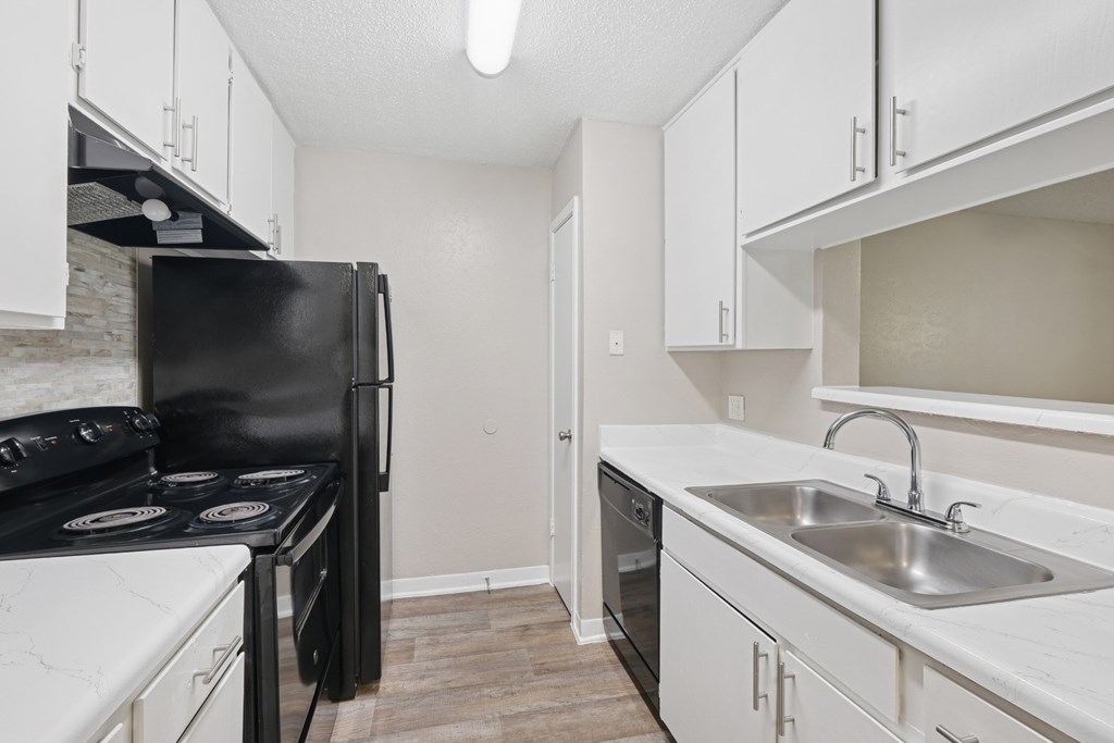 A3 kitchen with black appliances and white cabinets at Estelle Creek North Apartments in Irving, TX