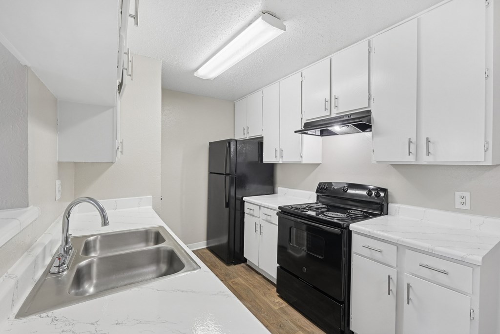 B1 kitchen with black appliances and white cabinets at Estelle Creek North Apartments in Irving, TX