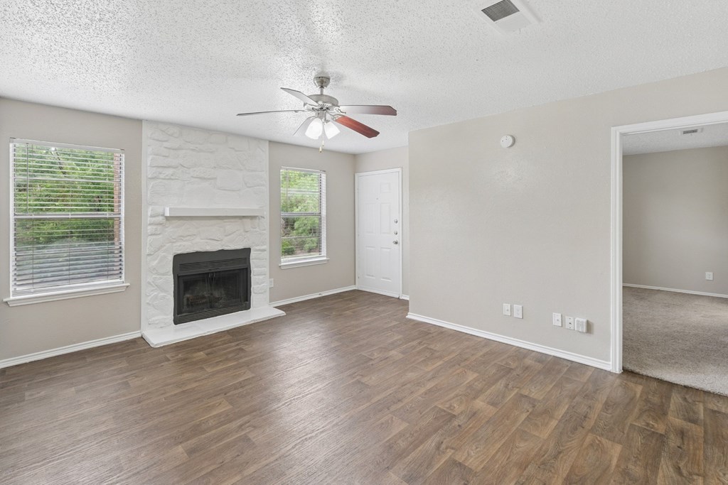 B1 living room with a fireplace and a ceiling fan at Estelle Creek North Apartments in Irving, TX