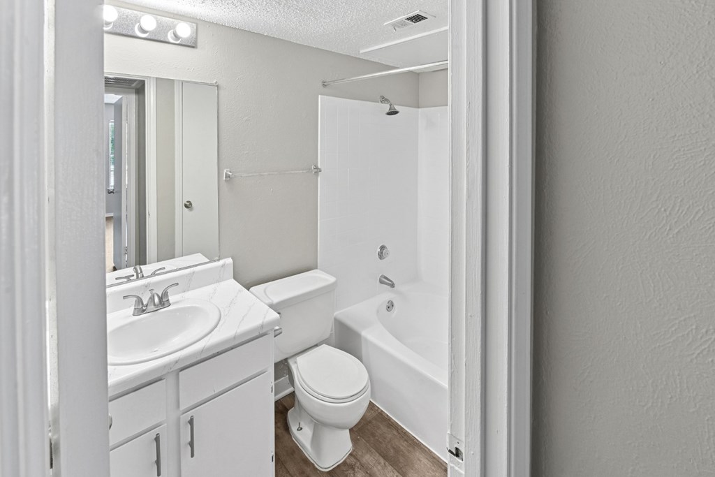A2 white bathroom with a toilet, sink, and bathtub at Estelle Creek North Apartments in Irving, TX