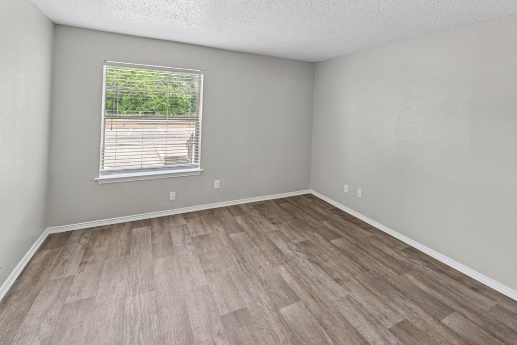 A2 bedroom with a window and wooden flooring at Estelle Creek North Apartments in Irving, TX