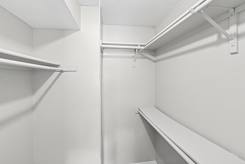 A2 walk in closet with white walls and shelves at Estelle Creek North Apartments in Irving, TX