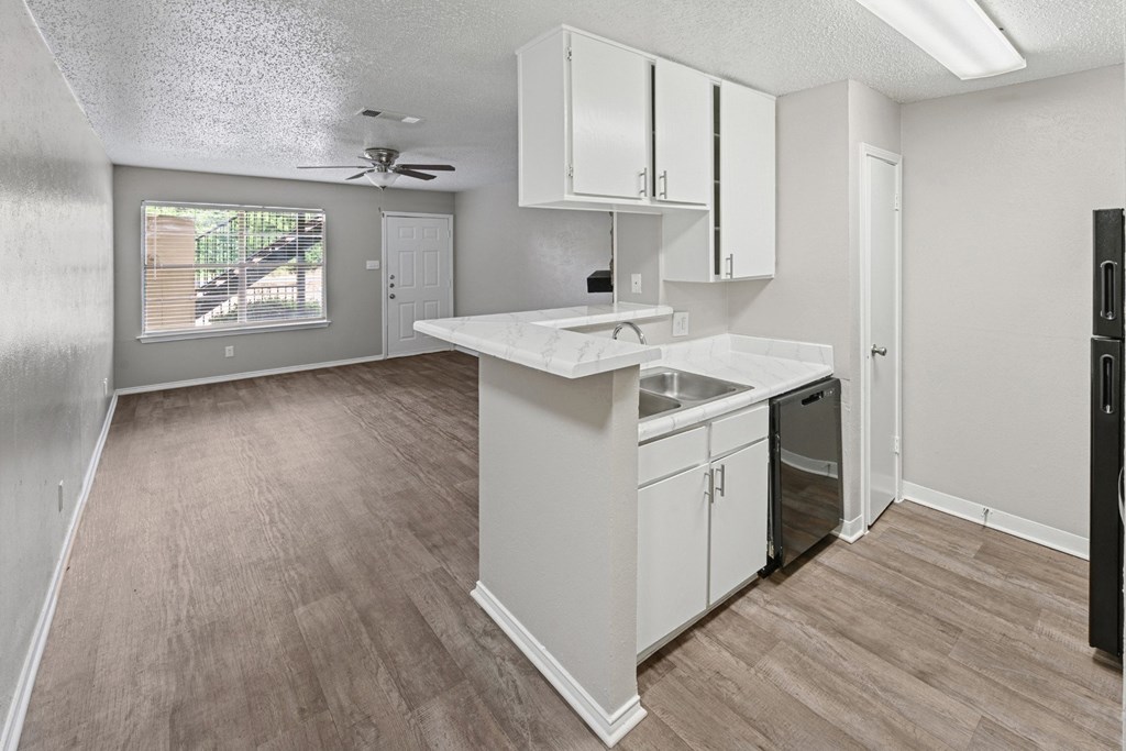 A2 kitchen with white cabinets and a wooden floor at Estelle Creek North Apartments in Irving, TX