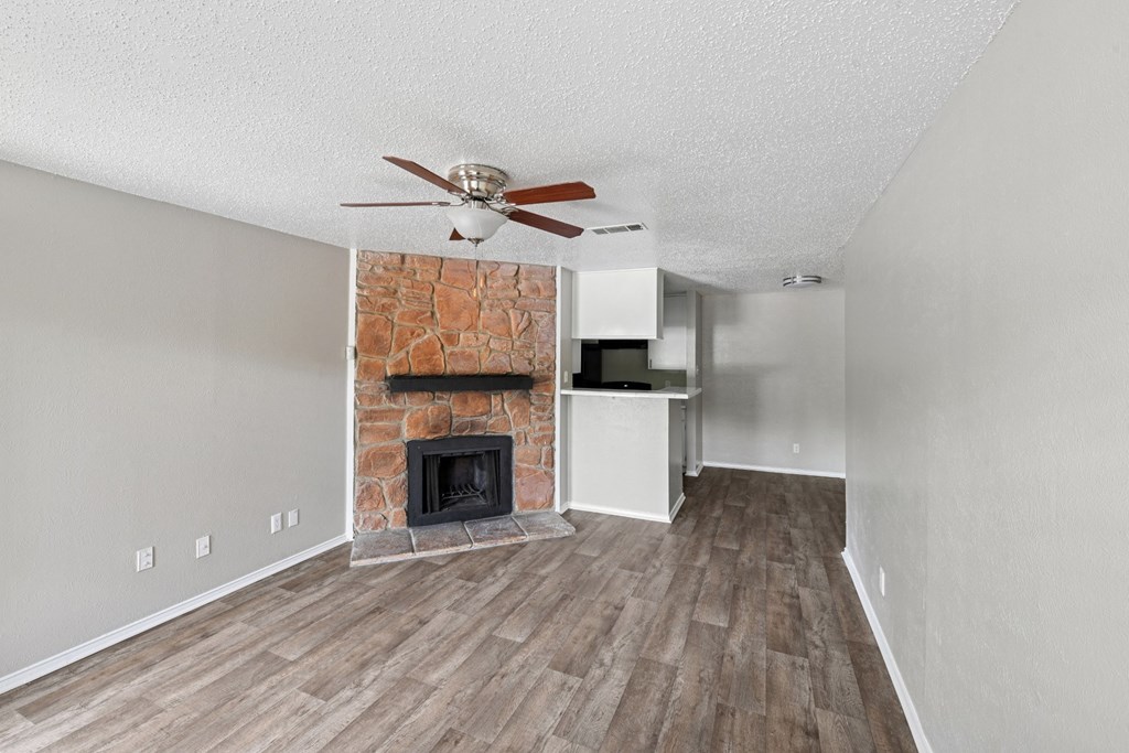 A2 living room with a fireplace and a ceiling fan at Estelle Creek North Apartments in Irving, TX