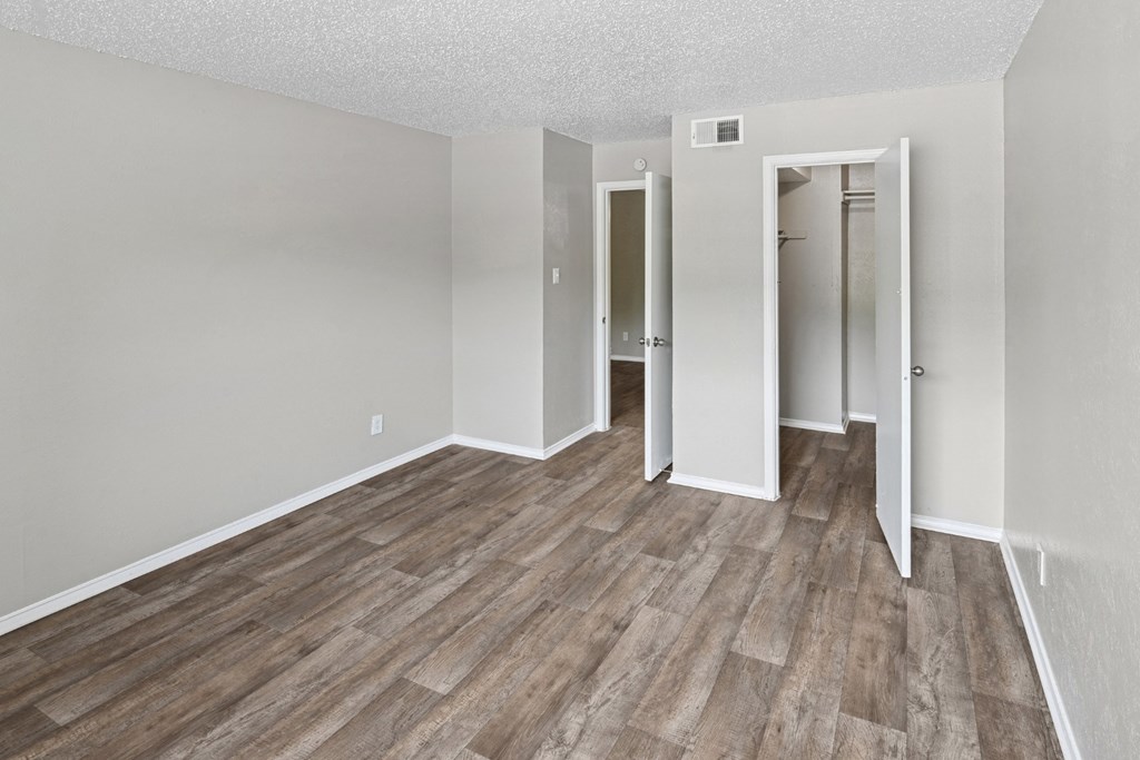 A2 bedroom with wood flooring, a closet, and white walls at Estelle Creek North Apartments in Irving, TX