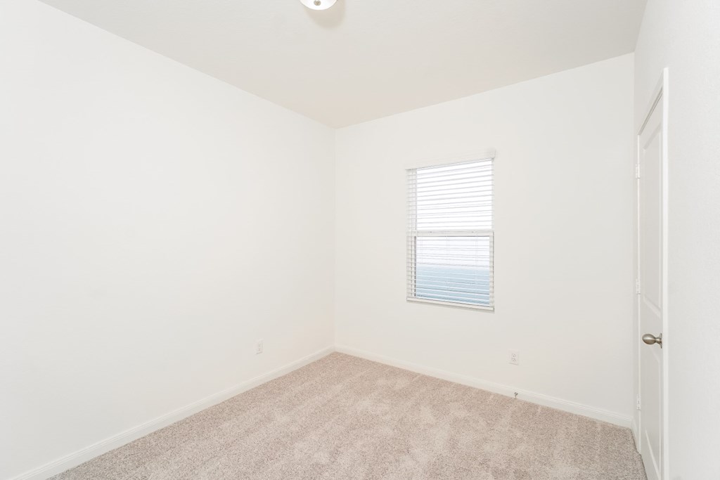 a bedroom with white walls and carpet at Beacon at Meridian, San Antonio, 78245