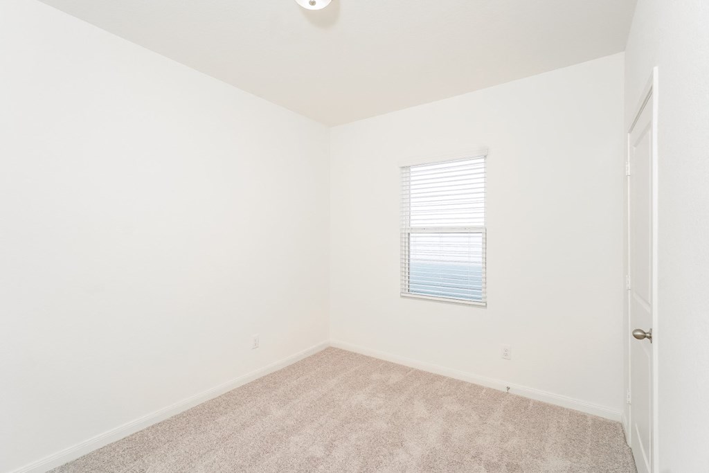 a bedroom with white walls and carpet