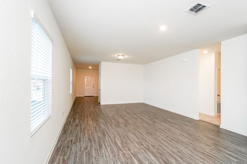 a bedroom with white walls and hardwood floors