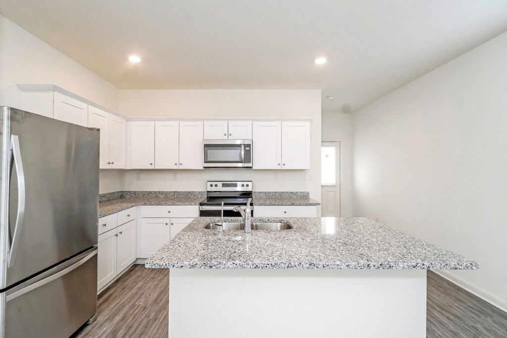 a kitchen with white cabinets and a granite counter top at Beacon at Meridian, San Antonio Texas