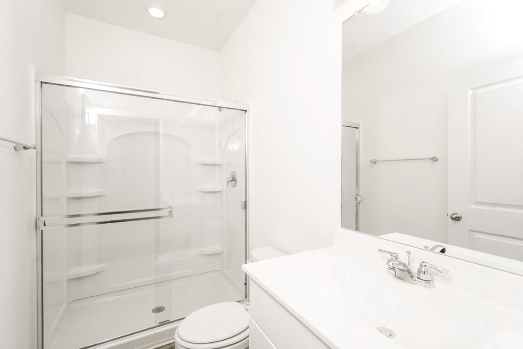 a bathroom with a white sink and toilet next to a glass shower at Beacon at Meridian, San Antonio, 78245