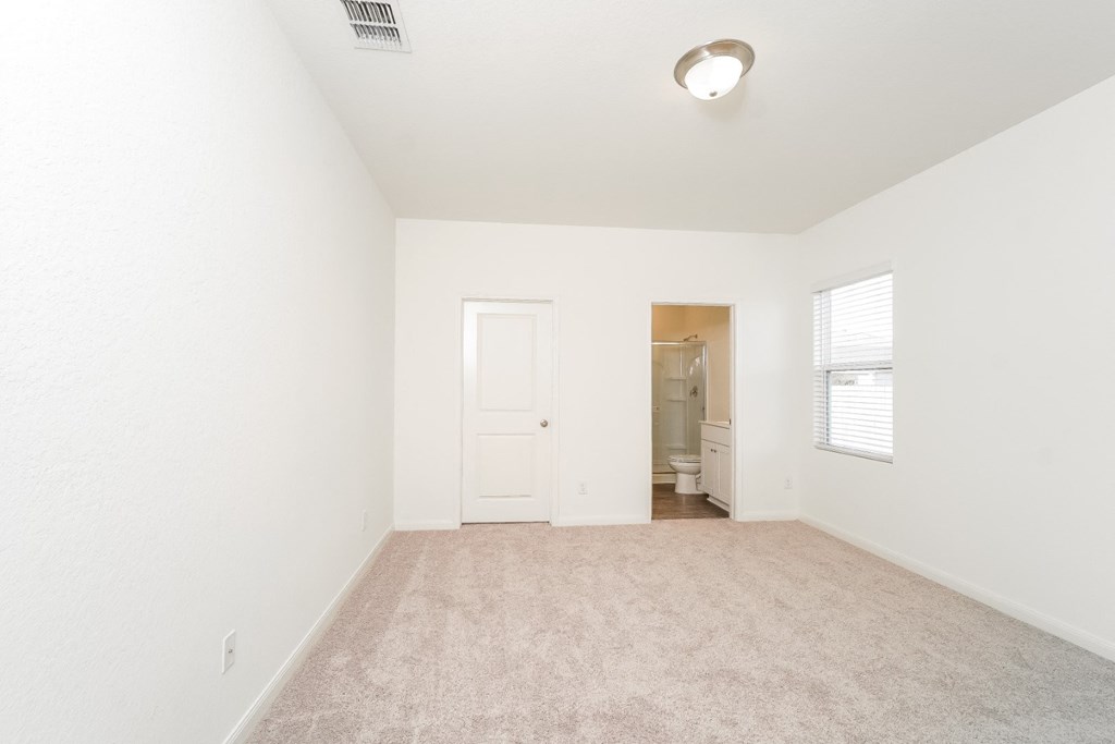 a bedroom with white walls and carpet