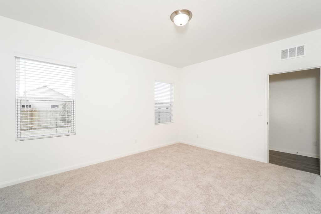 a bedroom with white walls and carpet at Beacon at Meridian, Texas