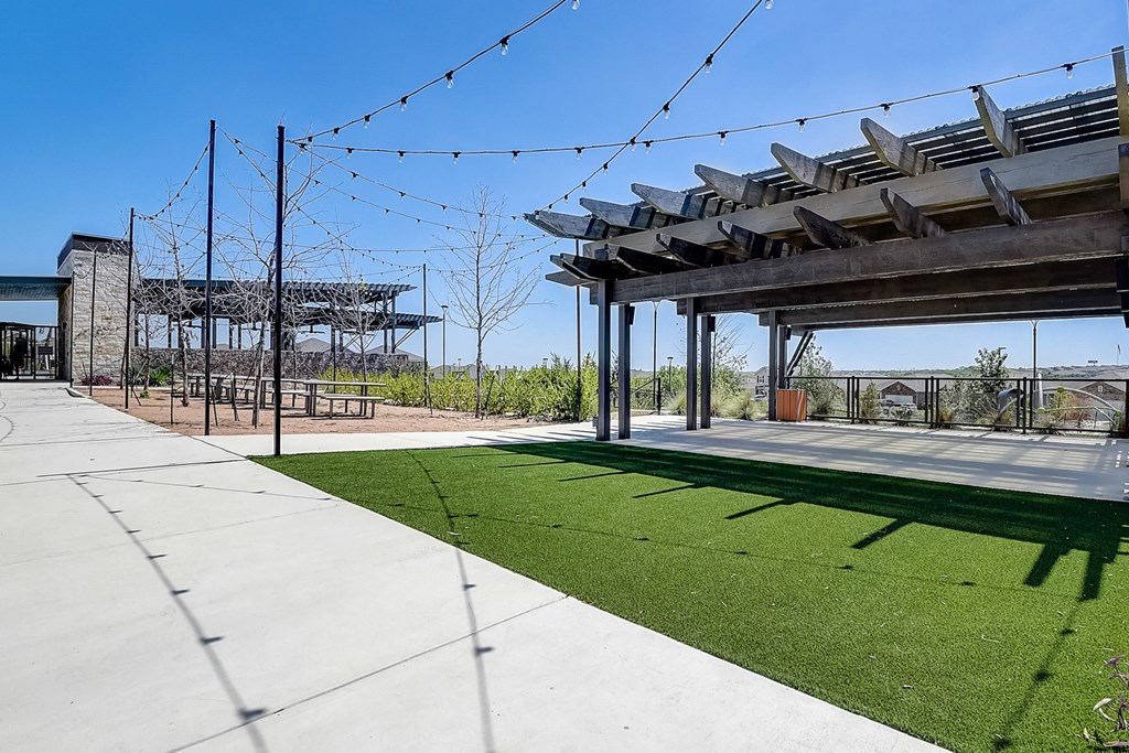 a grassy area with string lights and a pavilion in the background at Beacon at Meridian, San Antonio, 78245