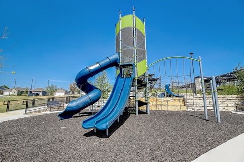 a large blue and yellow slide in a park at Beacon at Meridian, San Antonio