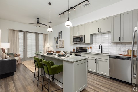 Model apartment open-concept kitchen and living room quartz countertops at Era apartments in Denton, TX