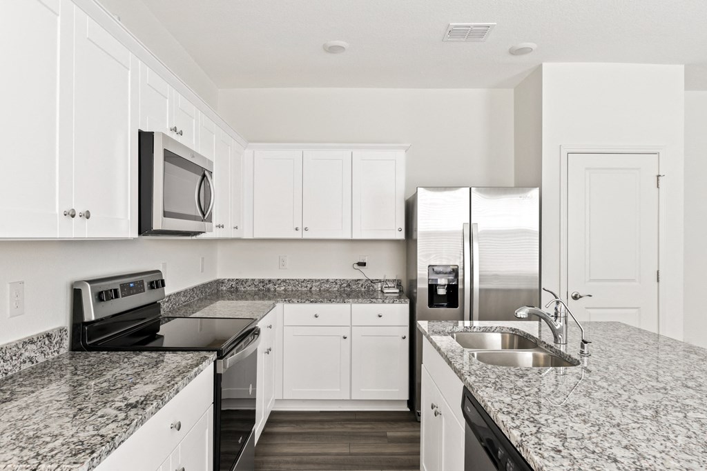 a kitchen with granite countertops and white cabinets