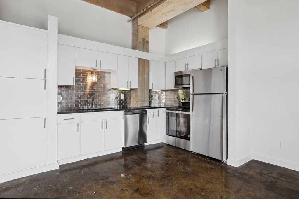 Farm and Ranch loft kitchen with white cabinets and stainless steel appliances | Deep Ellum Lofts in Dallas, TX