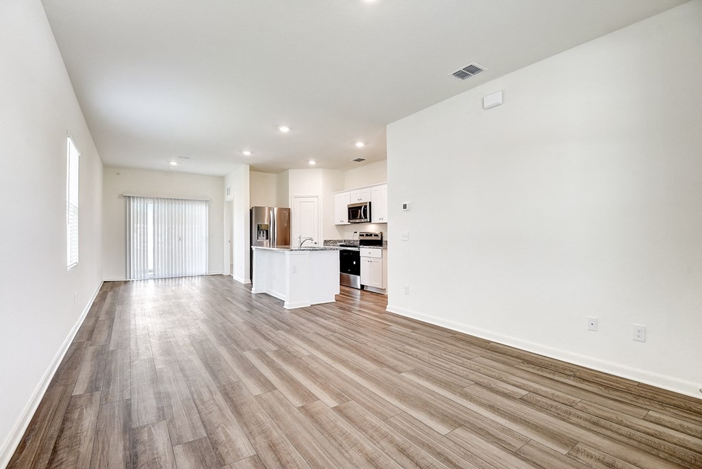 a bedroom with a medium sized bed and a kitchen with a stove and refrigerator at Beacon at Meridian, Texas, 78245