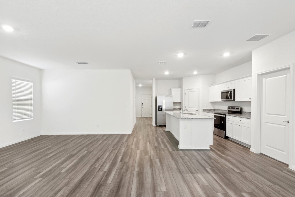 a living area with white walls and hardwood floors